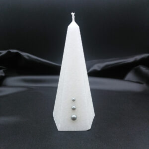 Bougie pyramidale blanche Aura Noël avec cristallisation givrée et trois perles argentées décoratives sur fond noir.