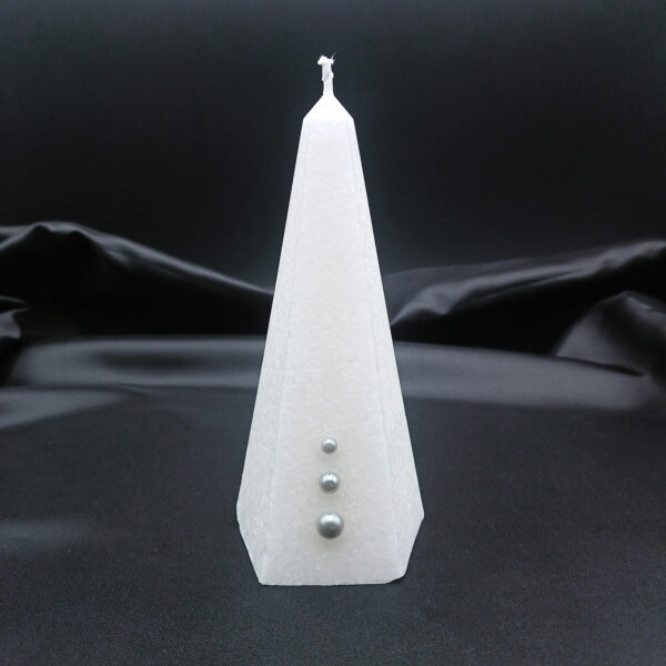 Bougie pyramidale blanche Aura Noël avec cristallisation givrée et trois perles argentées décoratives sur fond noir.