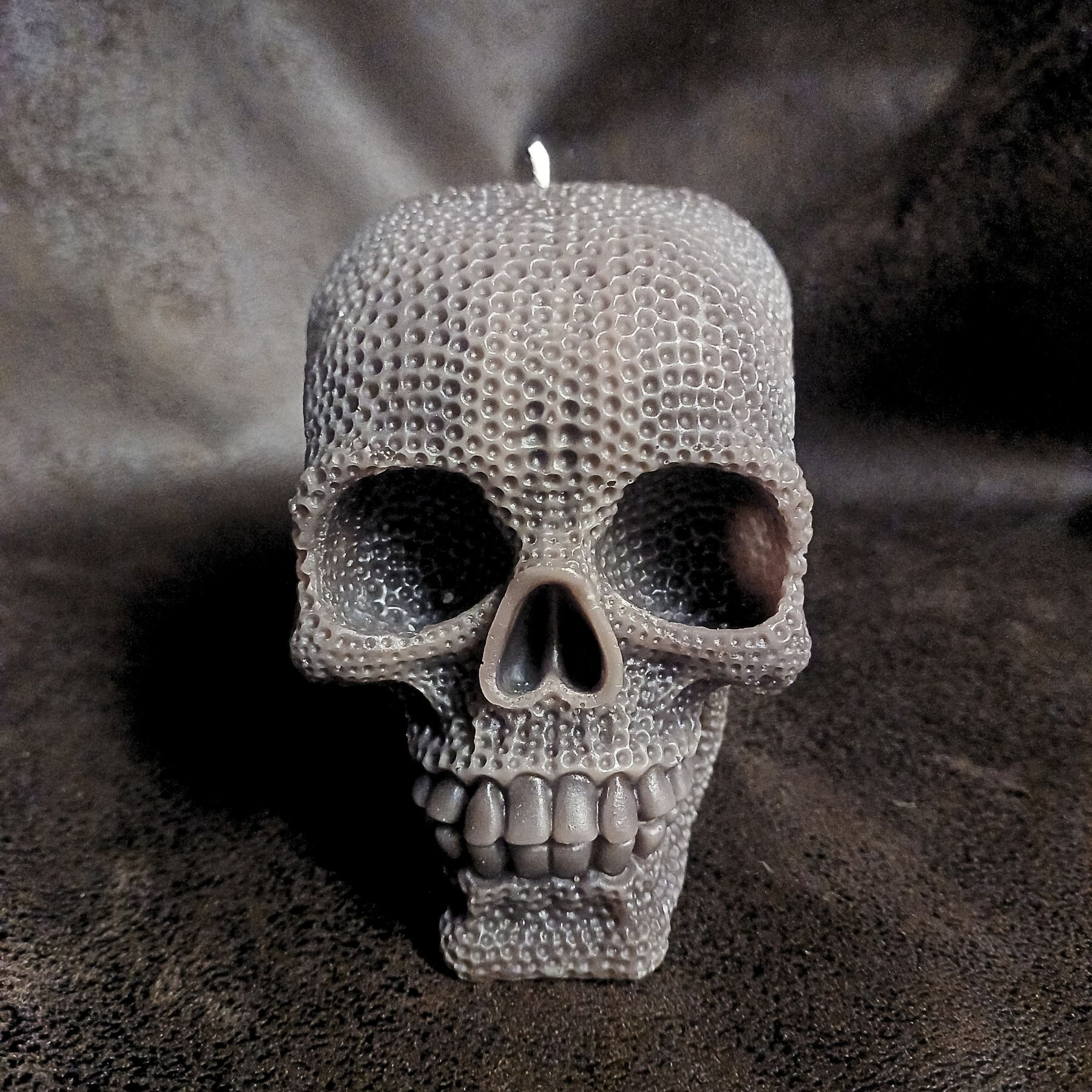 Bougies crâne Le Gardien - Bougie XXL, couleur marrron posée sur fond sombre